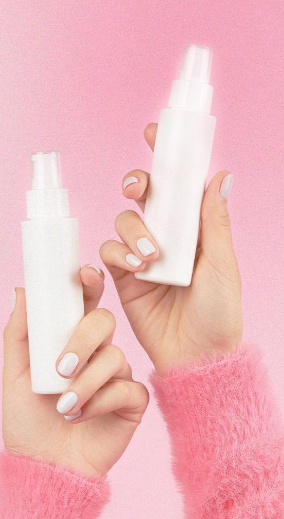Pink background, two hands holding white cosmetics bottles
